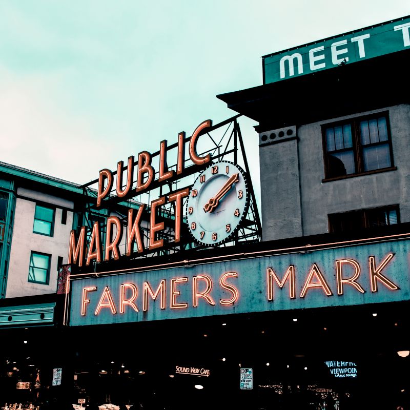 This image shows the iconic signage for a public market and farmers market on the exterior of a building, with surrounding architecture visible.